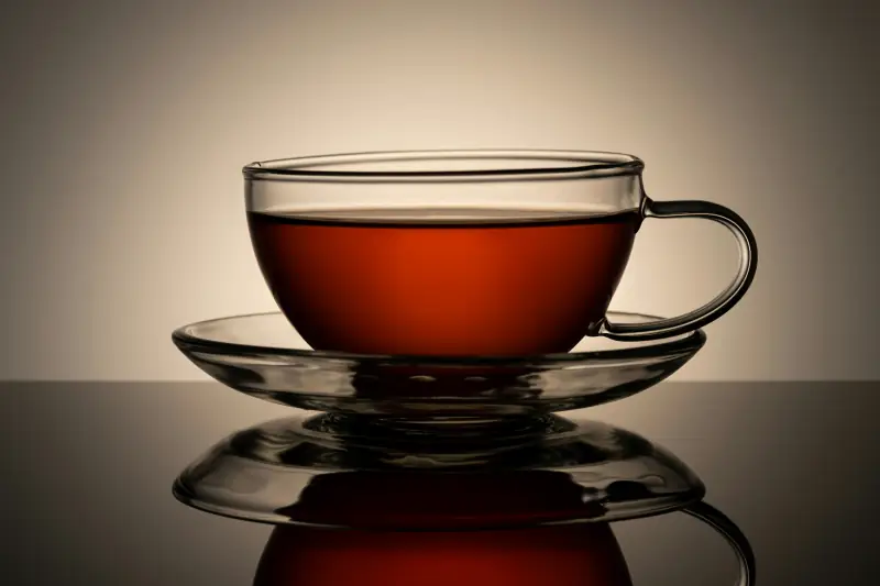 Gefüllte Teetasse aus Glas mit Untersetzer