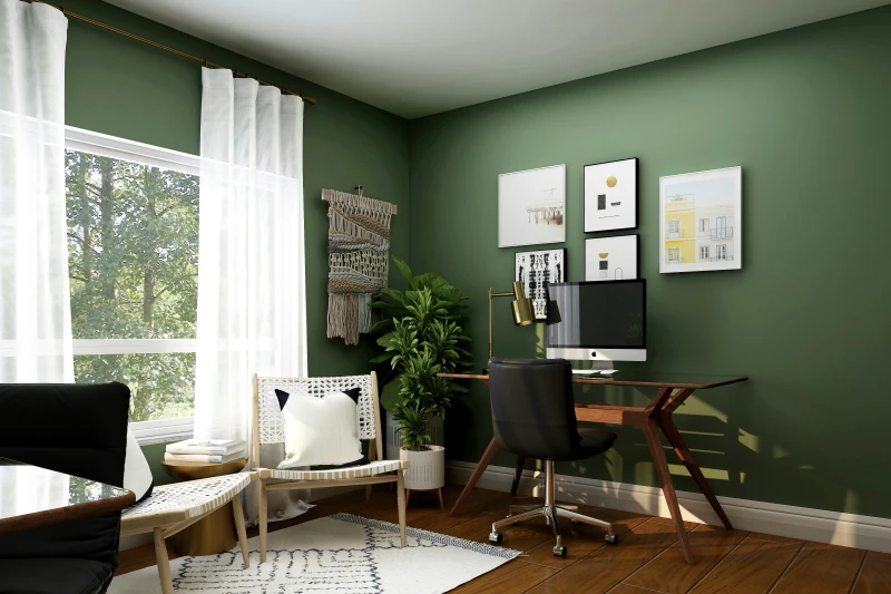 Eingerichtetes Homeoffice mit Schreibtisch, Sessel und Pflanzen vor grüner Wand
