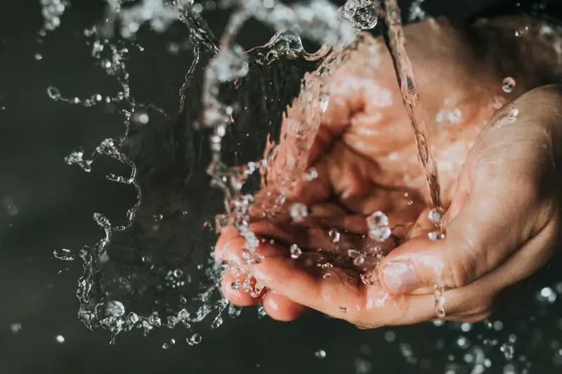 Hände unter Wasserstrahl