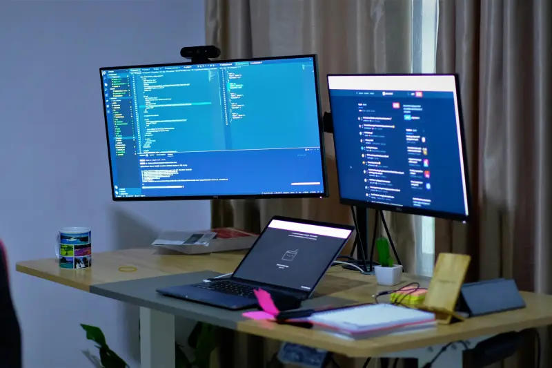 Arbeitsplatz mit Laptop und 2 Bildschirmen