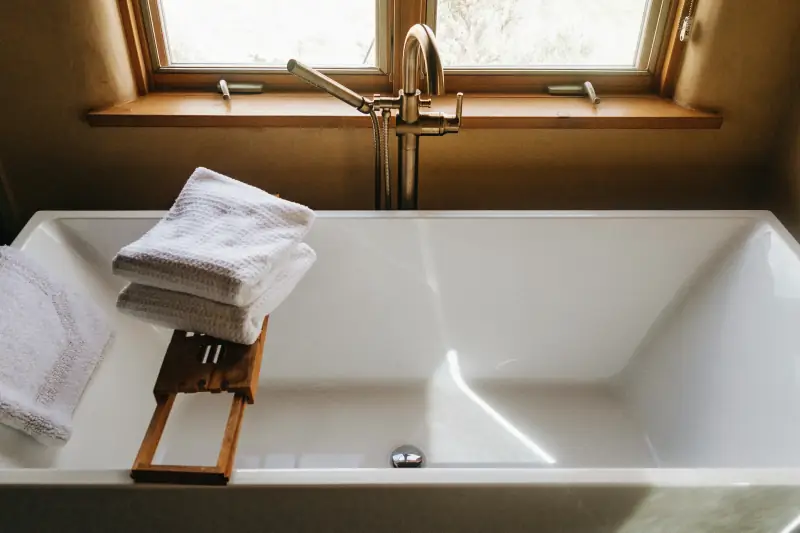 Weißes Handtuch auf weißer Badewanne von oben betrachtet