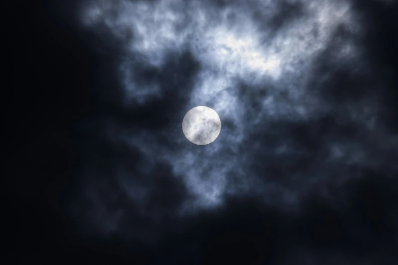 Heller Vollmond zwischen dunklen Wolken am Nachthimmel