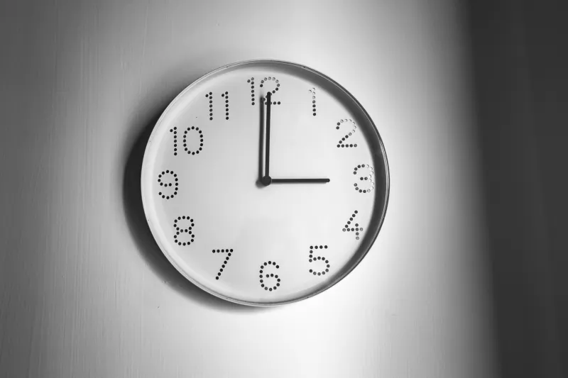 Wanduhr in Schwarz-Weiß zeigt 3 Uhr